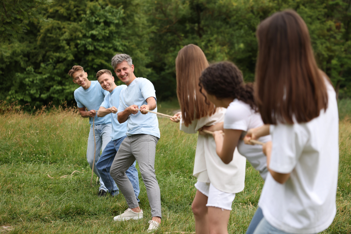 Teamevent - Seilziehen auf einer Wiese im Wald